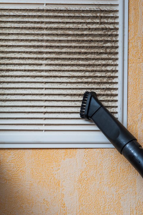 Cleaning ventilation grill with vacuum cleaner